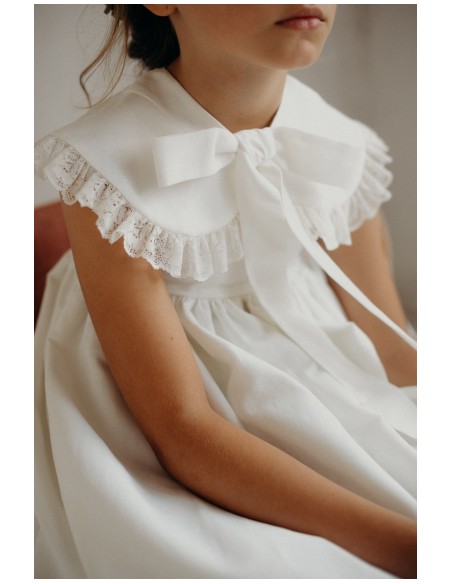 Vestido con solapas en escote con puntilla y lazo, confeccionado en lino color blanco roto. 
Marca Laniné Atelier.